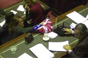 Alicia Castro deposita la bandera de Estados Unidos sobre la mesa del presidente del Congreso argentino, Eduardo Camaño. ASSOCIATED PRESS