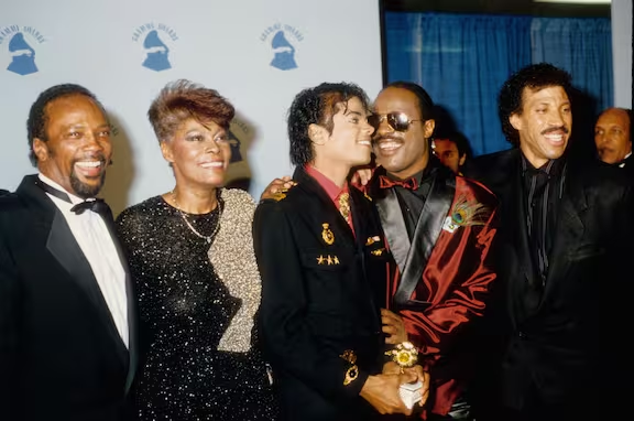 Michael Jackson y Quincy Jones junto a Dionne Warwick, Stevie Wonder y Lionel Richie posan para fotos en el backstage el 25 de febrero de 1986 en la 28.ª edición de los premios Grammy en el Shrine Auditorium de Los Ángeles, California. Foto: Getty Images